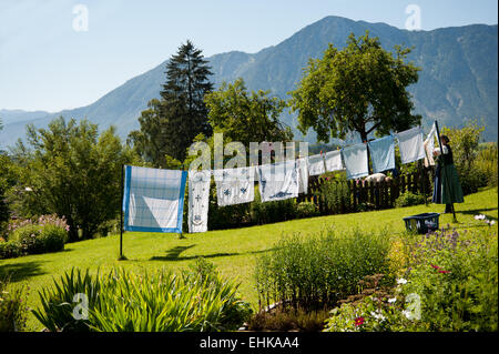 Woman hanging out le linge dans son jardin à Altaussee, Styrie, Autriche Banque D'Images