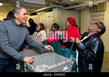 Le président américain Barack Obama partage un rire avec une femme au cours d'un projet d'action de grâces à pain pour la ville le 26 novembre 2014, à Washington, DC. Banque D'Images