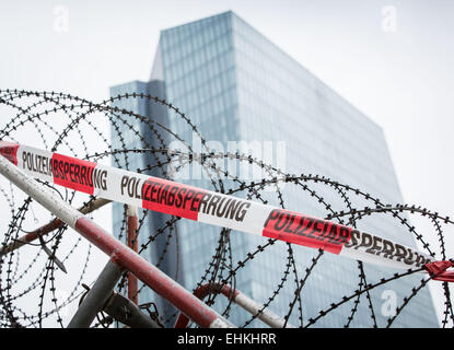 Nombre de barrières et barbelés en face du siège de la Banque centrale européenne qui se trouve à l'arrière-plan en Frankfurt a.M., Allemagne, 15 mars 2015. La police a commencé à fermer la zone quelques jours avant l'ouverture officielle du nouveau bâtiment. La Banque centrale européenne ouvre son siège le mercredi, 18 mars 2015. Le bâtiment a déjà été utilisé au cours des derniers mois. Plus de 10 000 personnes sont attendues pour différentes manifestations, rallyes et manifestations. Photo : FRANK RUMPENHORST/dpa Banque D'Images