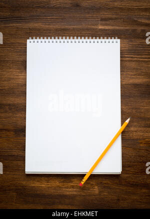 Papiers blanc vide dans un cahier avec un stylo sur le fond en bois Banque D'Images