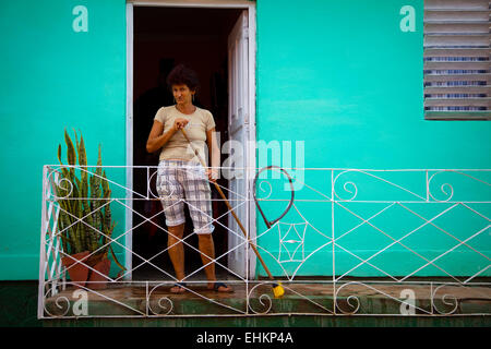 Une femme balaie sa maison à Trinidad, Cuba Banque D'Images