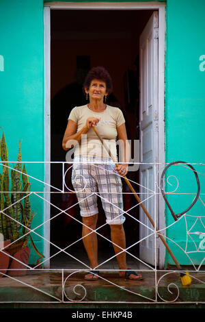 Une femme balaie sa maison à Trinidad, Cuba Banque D'Images