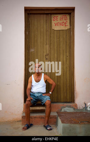 Un vieil homme est assis dans l'embrasure d'une porte à Trinidad, Cuba Banque D'Images