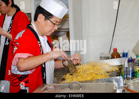 L'homme japonais nouilles aux oeufs de cuisson dans une cuisine Banque D'Images