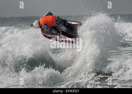 Homme jet ski concurrent exécute l'action de l'antenne se déplace dans de grandes vagues déferlantes sur la plage de Fistral Newquay Banque D'Images