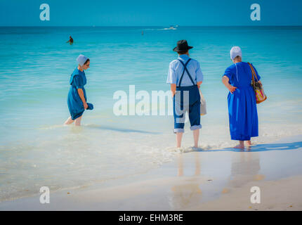 Trois Amish, vêtus de leur mode traditionnel de la pagaie dans les eaux de surf à Siesta Key Beach à Sarasota, FL, USA Banque D'Images