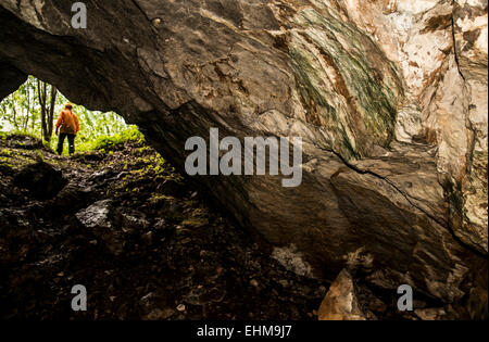 Caucasian woman standing outside rock formation cave Banque D'Images