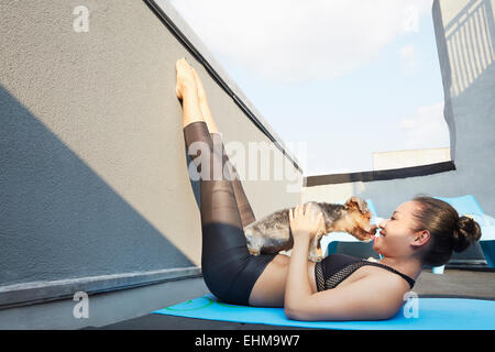 Chinese woman practicing yoga avec chien sur le pont Banque D'Images