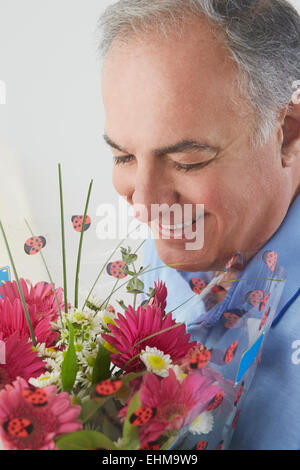 Hispanic man smelling bouquet de fleurs Banque D'Images