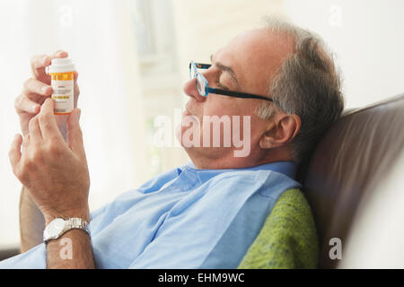 Hispanic man reading médicament de prescription bottle Banque D'Images