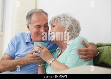 Vieux couple drinking coffee sur canapé Banque D'Images