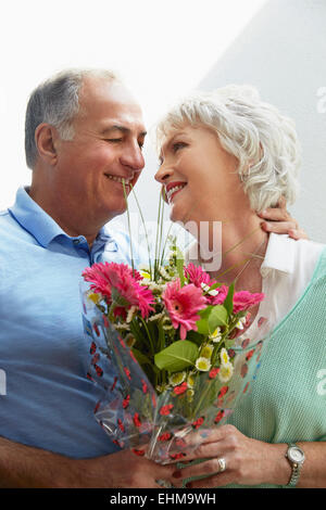 Vieux couple holding bouquet de fleurs Banque D'Images