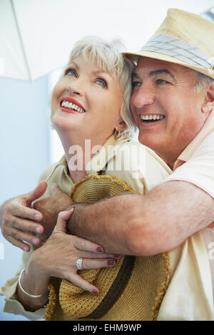 Vieux couple hugging outdoors Banque D'Images