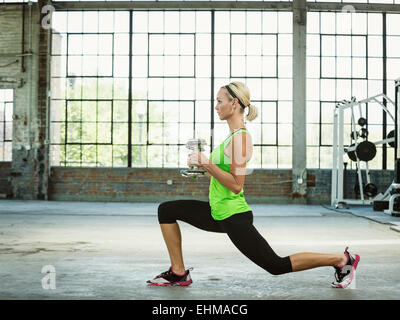 Caucasian woman lifting weights in gym Banque D'Images