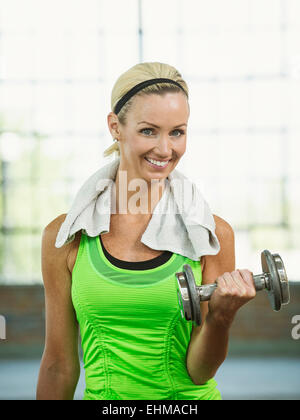 Caucasian woman lifting weights in gym Banque D'Images