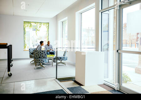 Black business people talking in office lobby Banque D'Images