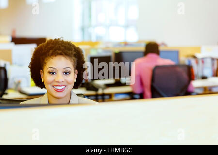 Businesswoman smiling at desk in office Banque D'Images