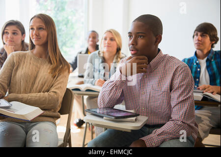 Teenage students listening in classroom Banque D'Images