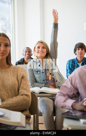 Teenage student raising hand in classroom Banque D'Images