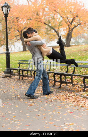 Smiling couple hugging in park Banque D'Images