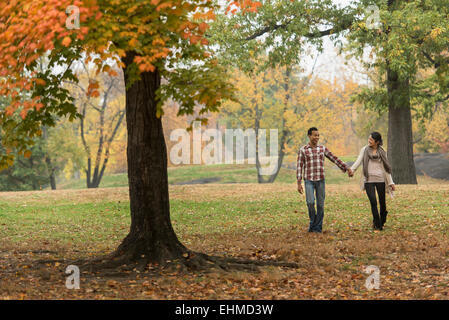 Couple holding hands and walking in park Banque D'Images