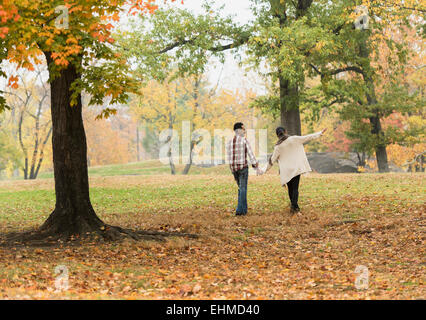 Couple holding hands and walking in park Banque D'Images