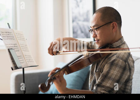 Musicien Coréen à jouer du violon dans la salle de séjour Banque D'Images