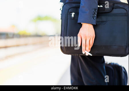 Black businessman holding cigarette à l'extérieur Banque D'Images