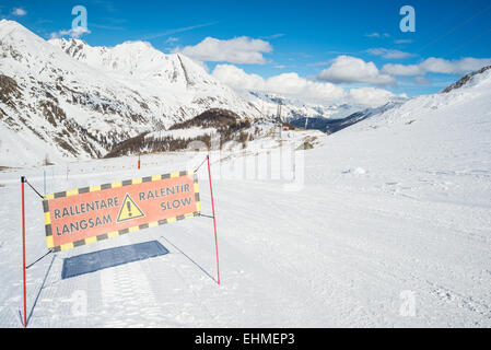 Ski 'lent' warning sign on ski dans ski avec vue panoramique sur le majestueux des Alpes italiennes. Banque D'Images