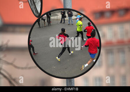 Miroir convexe avec la réflexion d'athlètes exécutant le demi-marathon Hervis à Prague, République tchèque. Banque D'Images