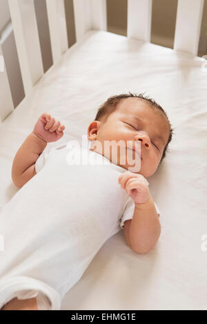Mixed Race baby sleeping in crib Banque D'Images