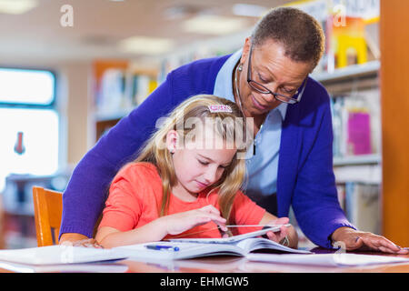 Aider les enseignants étudiants digital tablet in library Banque D'Images