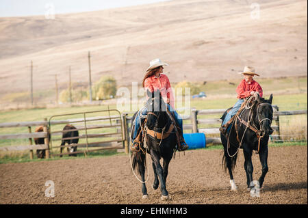 Caucasian mother and son riding horses ranch sur Banque D'Images