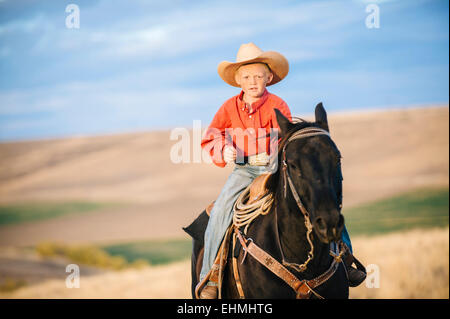 Woman riding horse in grassy field Banque D'Images