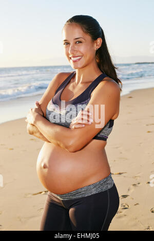 Pregnant Hispanic woman smiling on beach Banque D'Images