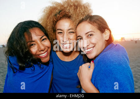 Les femmes hispaniques enveloppée de couverture sur beach Banque D'Images