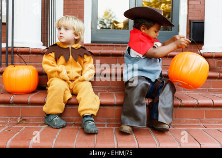 Les garçons en costumes truc assis sur l'avant s'abaisser à l'Halloween Banque D'Images