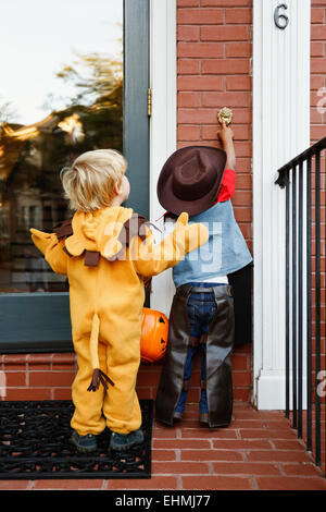 Les garçons en costumes trick or treating ensemble sur l'Halloween Banque D'Images