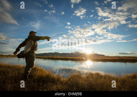 Fisherman casting in river Banque D'Images