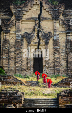 Les moines d'Asie sous les parasols debout près de temple historique, Mingun, Mandala, Myanmar Banque D'Images