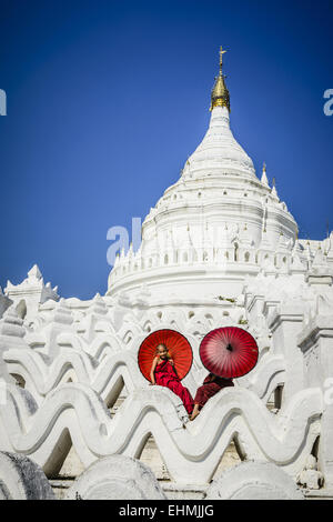 Les moines asiatiques assis sous les parasols au temple historique, Mingun, Mandala, Myanmar Banque D'Images