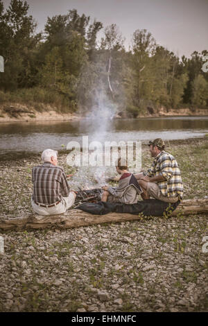 Trois générations d'hommes de race blanche se reposer près de camp Banque D'Images