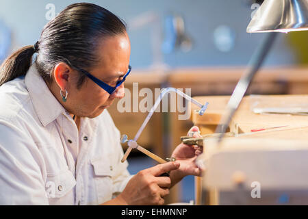 Native American bijoutier travaillant en studio Banque D'Images