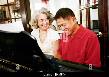 Couple playing piano de concert dans la salle de séjour Banque D'Images