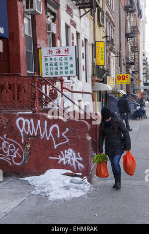 Femme marche avec l'épicerie dans le quartier chinois, la ville de New York. Banque D'Images