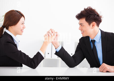 Business man and woman Arm wrestling on desk in office Banque D'Images