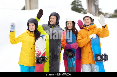 Happy friends dans casques avec snowboards Banque D'Images