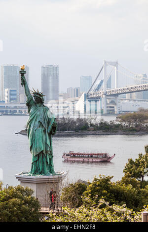 Statue de la liberté sur le bord de la baie de Tokyo et le Rainbow Bridge, au Japon. Banque D'Images
