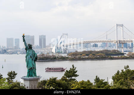 Statue de la liberté sur le bord de la baie de Tokyo et le Rainbow Bridge, au Japon. Banque D'Images