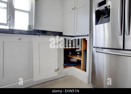 Une cuisine moderne blanc dans une maison au Royaume-Uni avec l'encoignure porte ouverte. Banque D'Images